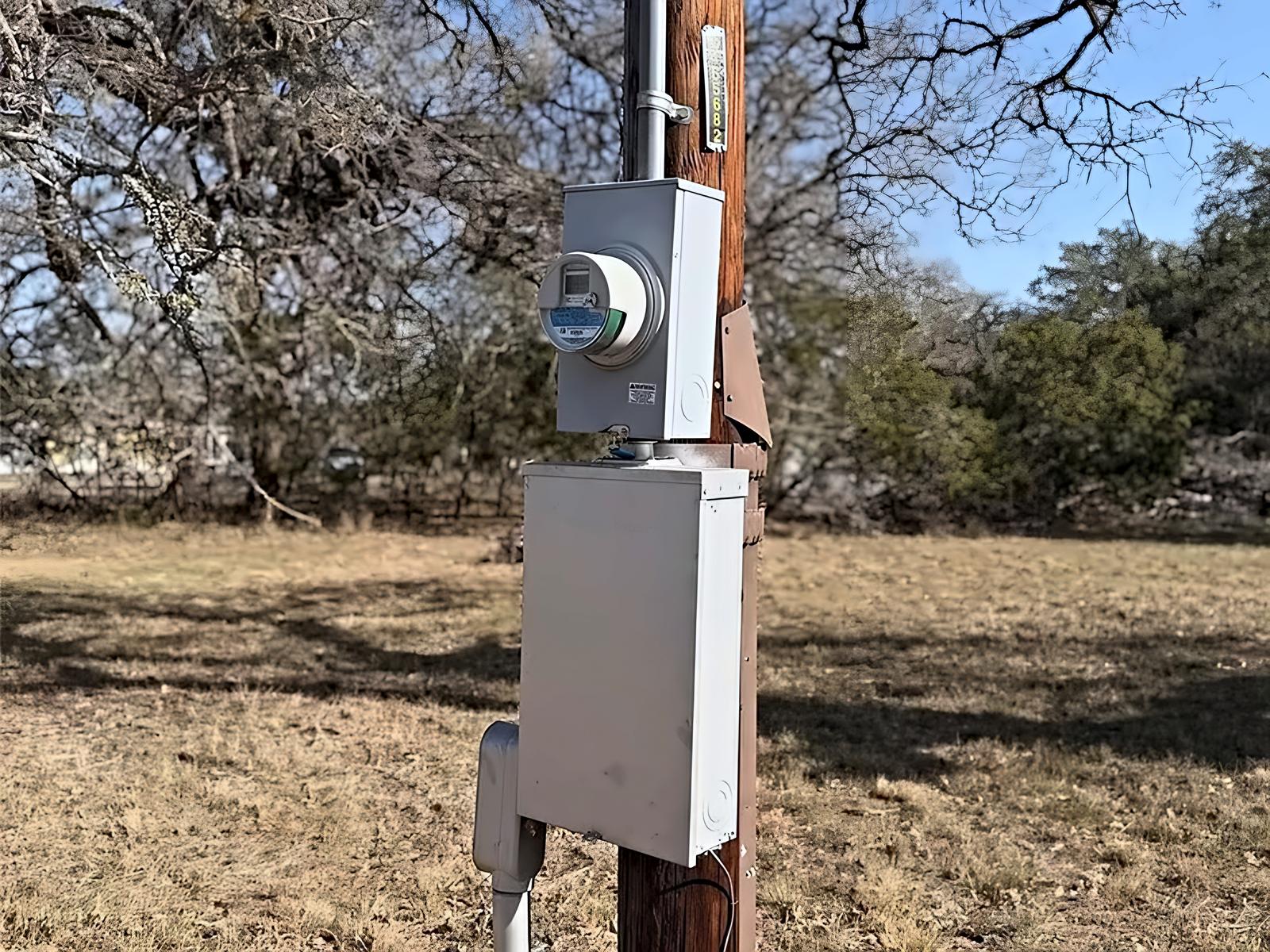 Electric meter and service panel mounted on a utility pole